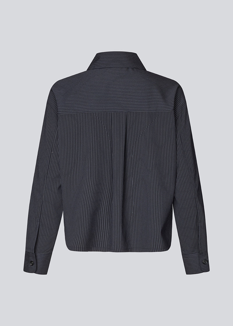 Slightly cropped shirt with wide sleeves. Paitynmd shirt has a front button closure, shirt collar, and a chest pocket.