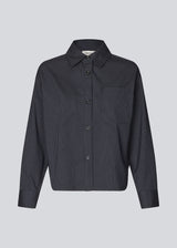 Slightly cropped shirt with wide sleeves. Paitynmd shirt has a front button closure, shirt collar, and a chest pocket.