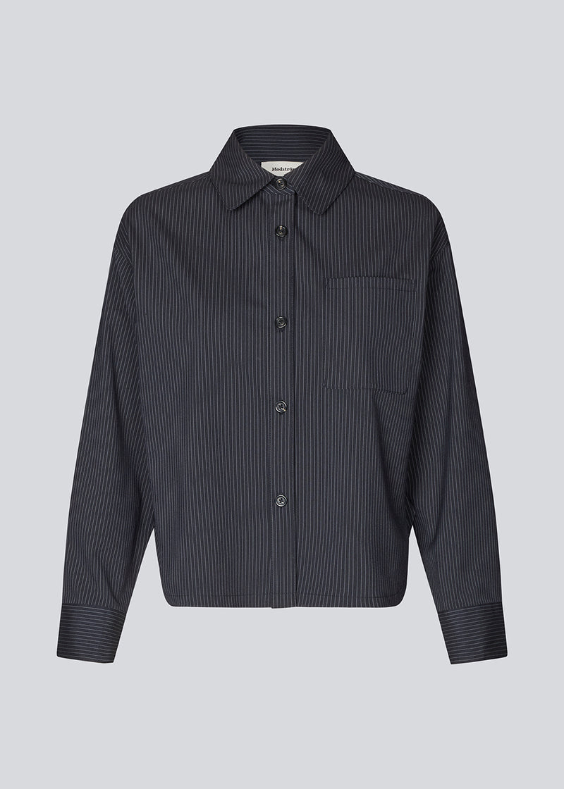 Slightly cropped shirt with wide sleeves. Paitynmd shirt has a front button closure, shirt collar, and a chest pocket.