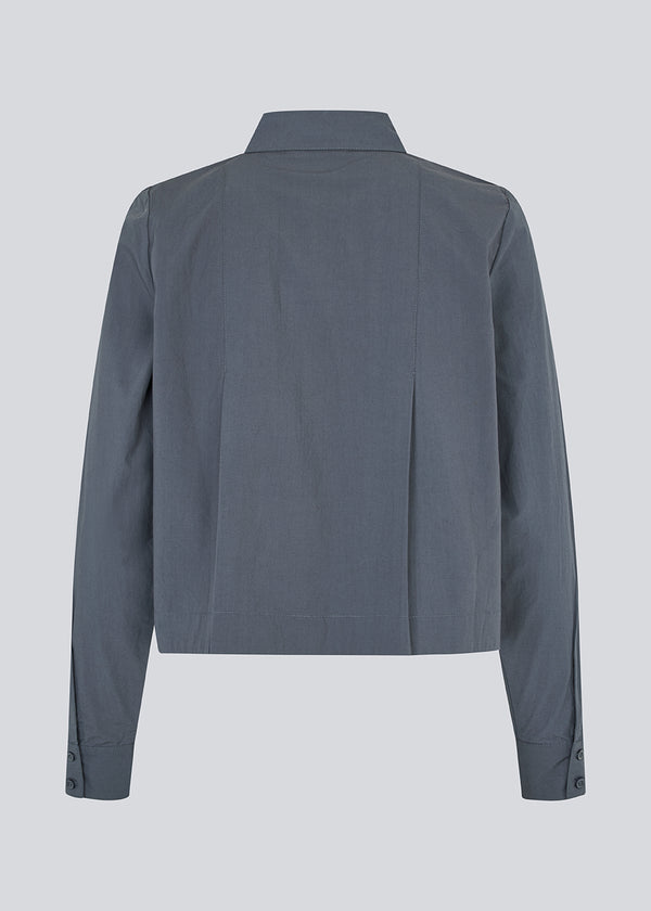 Short pleated shirt in 100% organic cotton. Palmermd solid shirt has a shirt collar and a button closure in front.