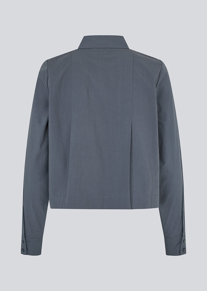 Short pleated shirt in 100% organic cotton. Palmermd solid shirt has a shirt collar and a button closure in front.