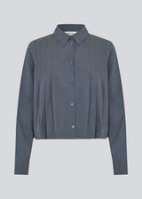 Short pleated shirt in 100% organic cotton. Palmermd solid shirt has a shirt collar and a button closure in front.