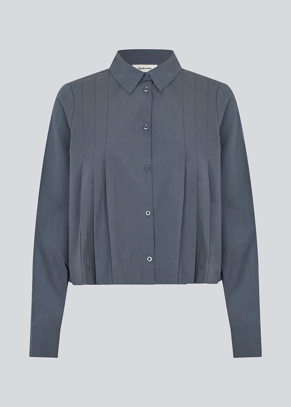 Short pleated shirt in 100% organic cotton. Palmermd solid shirt has a shirt collar and a button closure in front.