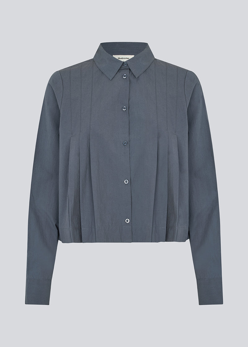 Short pleated shirt in 100% organic cotton. Palmermd solid shirt has a shirt collar and a button closure in front.