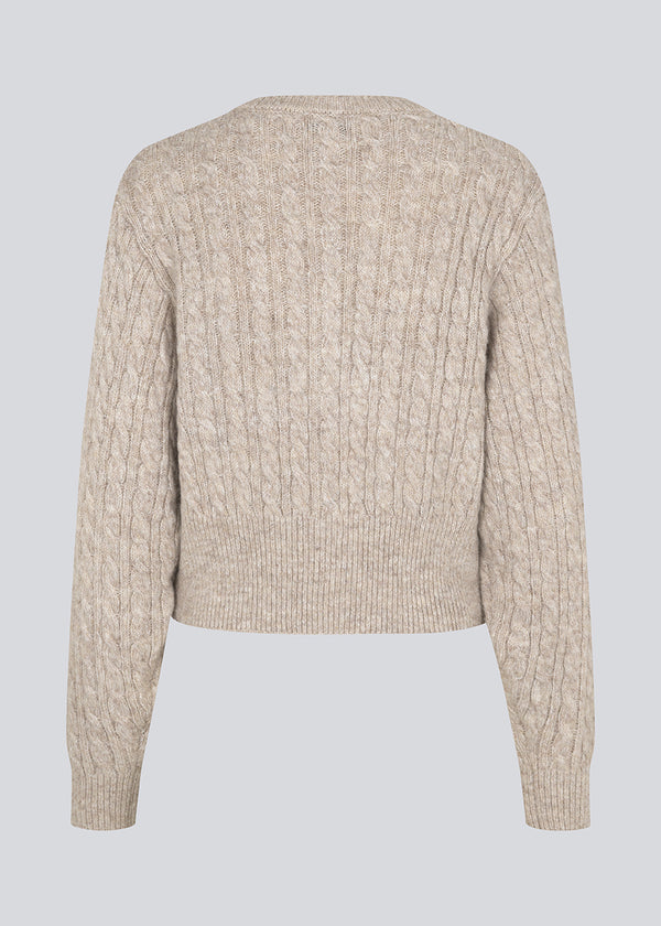 Knitted cable knit cardigan with pearl buttons. Pammiemd cardigan has a round neckline and ribbed hem.
