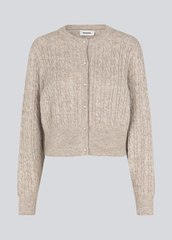 Knitted cable knit cardigan with pearl buttons. Pammiemd cardigan has a round neckline and ribbed hem.