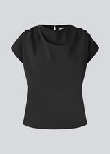 Fitted top with ruffled details. Pandymd top has short sleeves and an opening in the back with button closure.