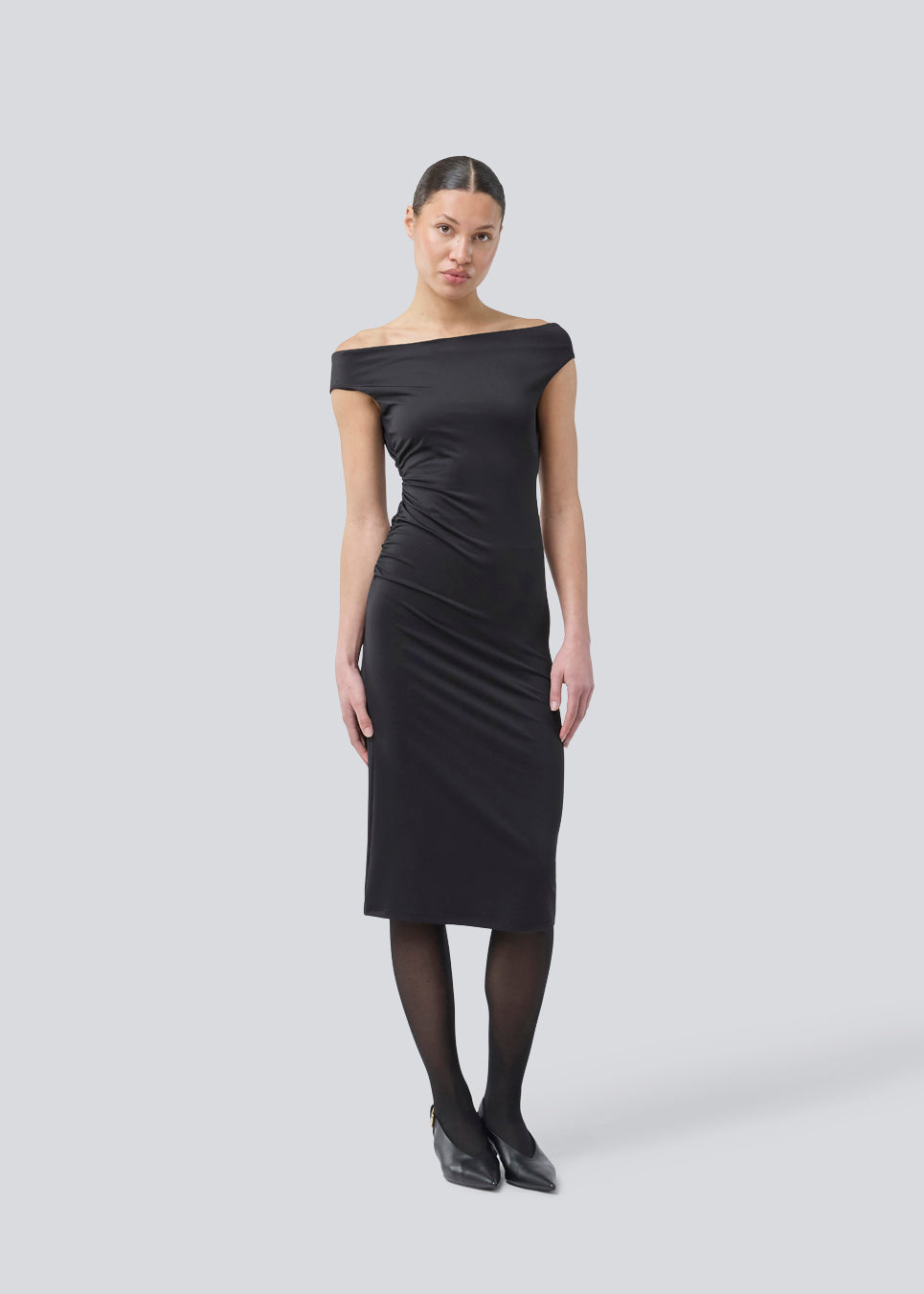 Long off-shoulder dress in elastic recycled material. Parissamd dress is fitted and has ruffle details at the sides. The model is 175 cm and wears a size S/36.