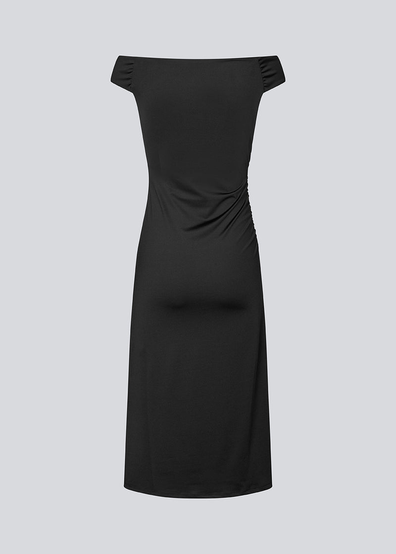 Long off-shoulder dress in elastic recycled material. Parissamd dress is fitted and has ruffle details at the sides. The model is 175 cm and wears a size S/36.