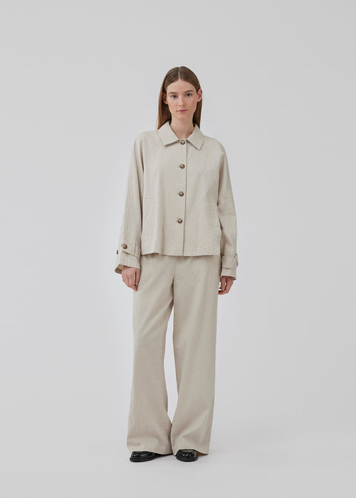 Short trench coat with a casual look in a linen and cotton quality. ParkMD short jacket has a collar, buttons in front, two front pockets, and a strap with button at the cuff. The model is 175 cm and wears a size S/36.