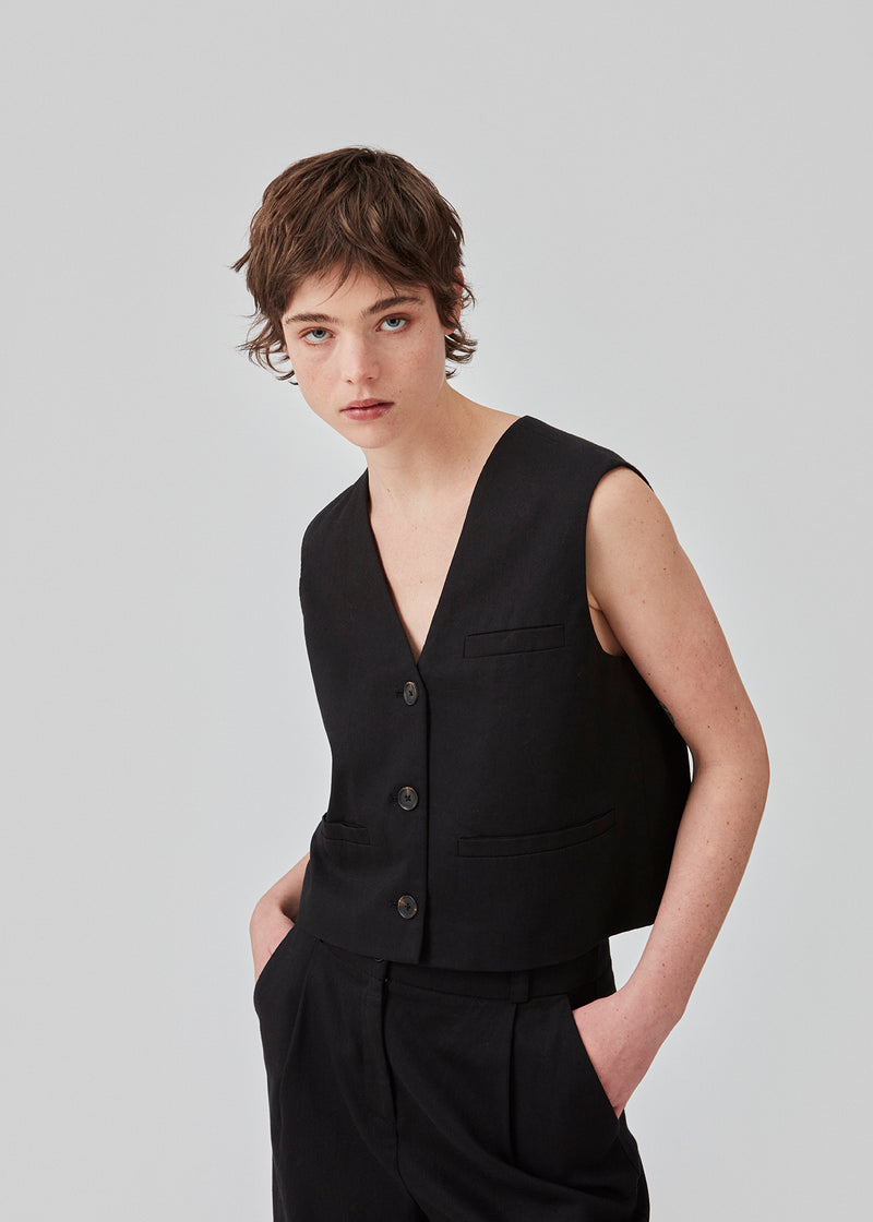Short waistcoat in a woven linen blend. ParkMD vest has a deep v-neck with buttons and a relaxed and loose silhouette. The model is 175 cm and wears a size S/36.