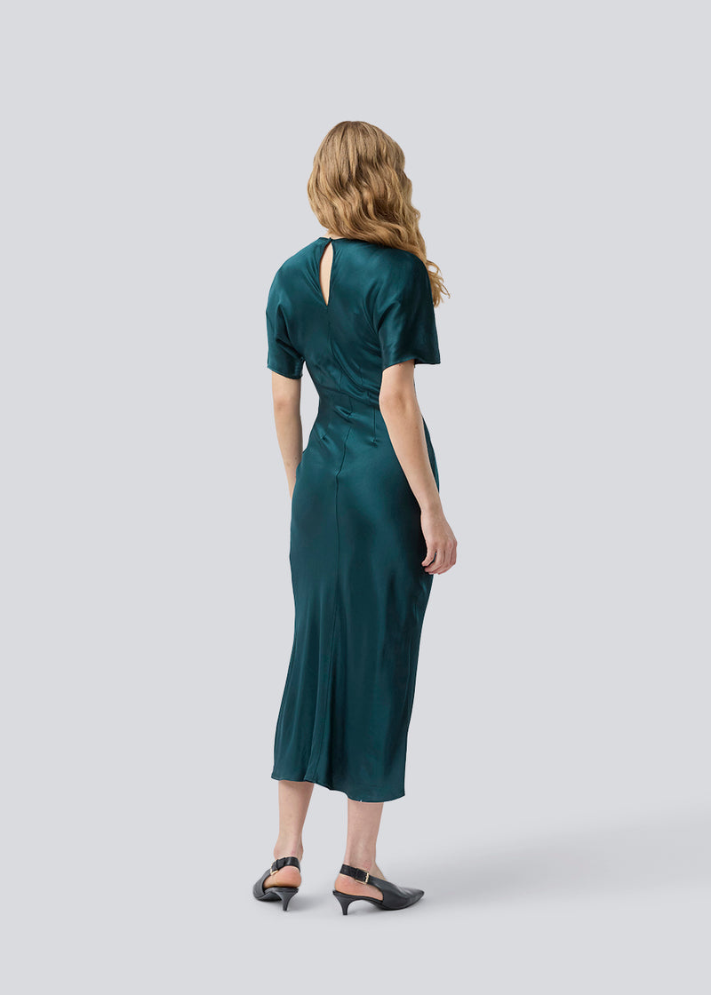 Green long satin dress with draping detail. Parveenmd dress has short sleeves and an invisible zipper in the back. The model is 175 cm and wears a size s/36.
