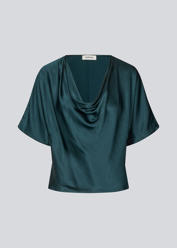 Dark green satin top with a waterfall detail. Parveenmd top is fitted and has short sleeves.&nbsp;
