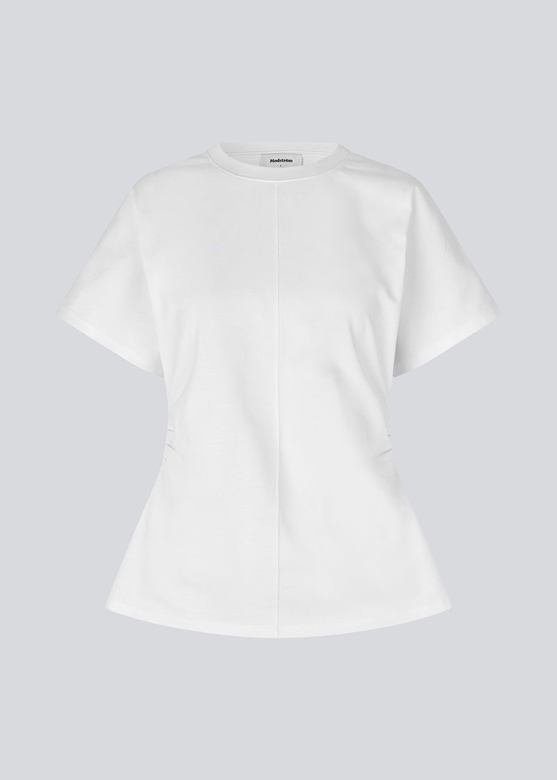 Fitted T-shirt with short sleeves. Patayamd t-shirt has a round neck and ruffles in the side seam. The model is 175 cm and wears a size s/36.