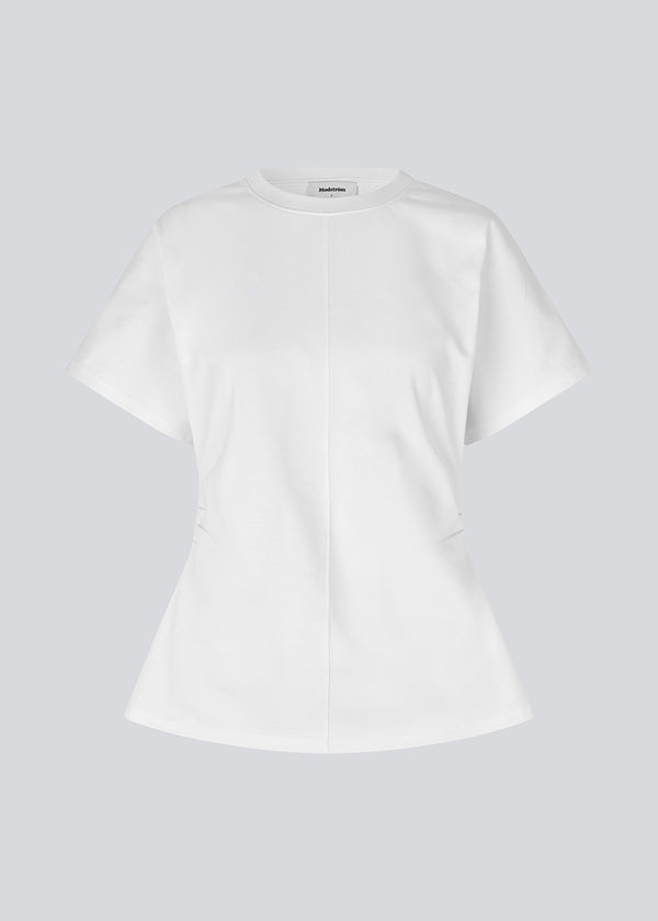 Fitted T-shirt with short sleeves. Patayamd t-shirt has a round neck and ruffles in the side seam. The model is 175 cm and wears a size s/36.