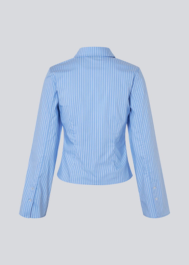 Classic fitted shirt in a cotton mix. Pattimd shirt has a collar, button closure in front, and long wide sleeves. The model is 175 cm and wears a size S/36.