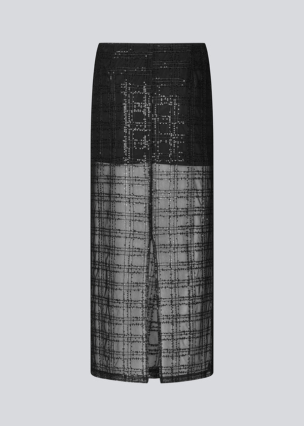 Long skirt in a transparent material with sequins. Pearleenmd long skirt has lining, an invisible side zipper, and a slit.