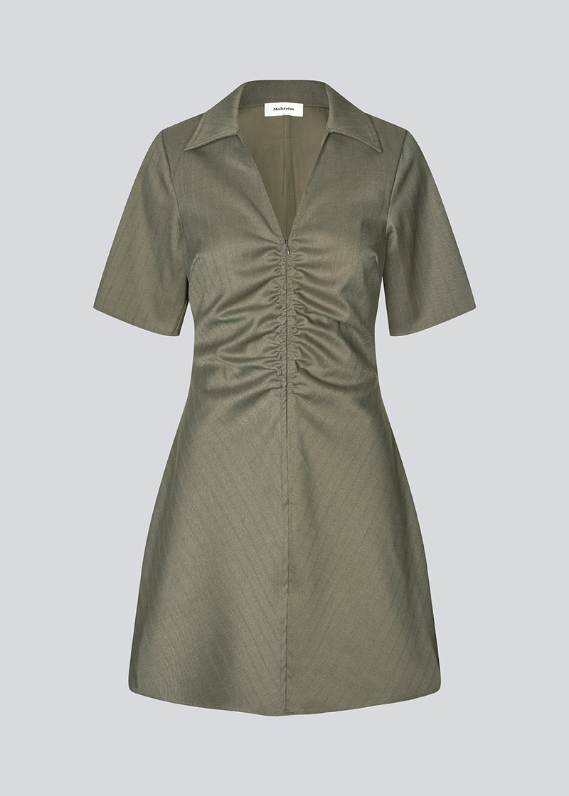Fitted dress with short sleeves and gathering detail. Pedromd dress has a V-neckline and an invisible front zipper. The model is 175 cm and wears a size S/36.
