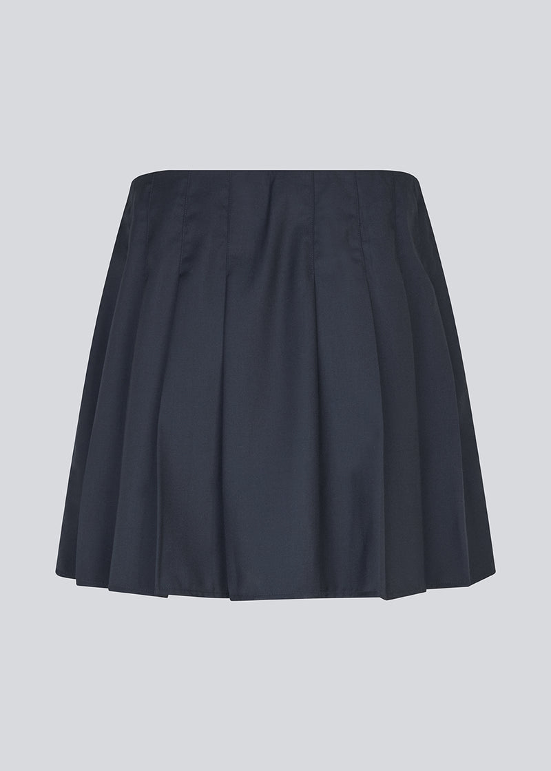 Short skirt with box pleats and a medium high waist. Peggiemd skirt has a hidden zipper in the side. The model is 175 cm and wears a size s/36.