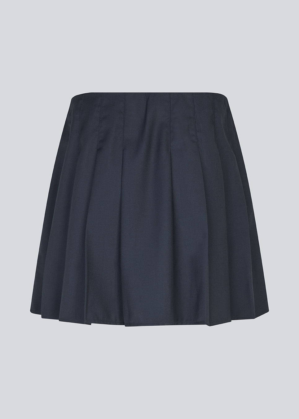 Short skirt with box pleats and a medium high waist. Peggiemd skirt has a hidden zipper in the side. The model is 175 cm and wears a size s/36.
