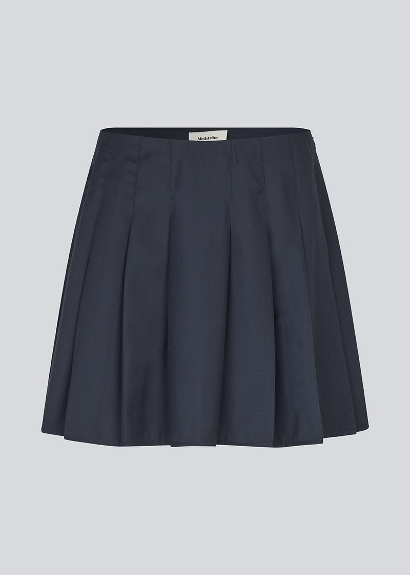 Short skirt with box pleats and a medium high waist. Peggiemd skirt has a hidden zipper in the side. The model is 175 cm and wears a size s/36.
