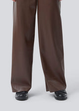 Loose trousers in 100% PU. Pellemd pants have a high waist with elastic and side pockets. The model is 175 cm and wears a size s/36.