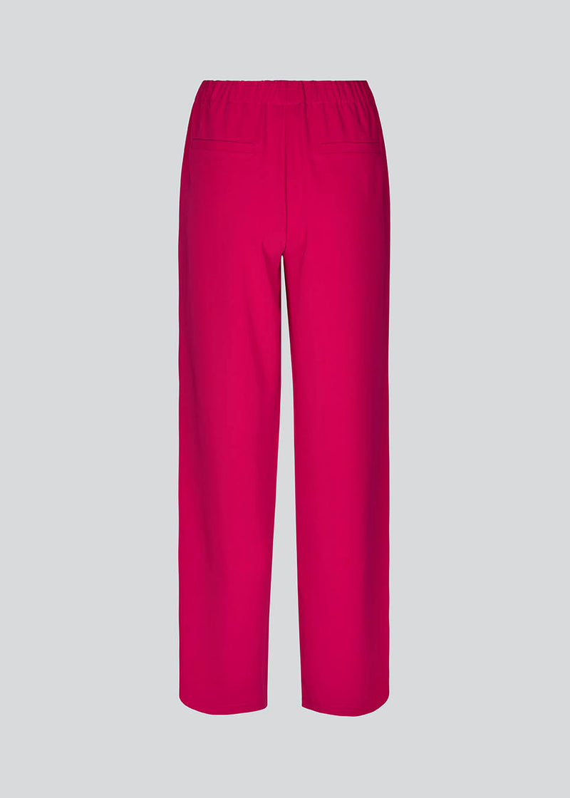 Pink pants in a simple design with wide legs. Perry pants have pockets at side seam and an elasticated waistline for a comfortable fit. The model is 173 cm and wears a size S/36