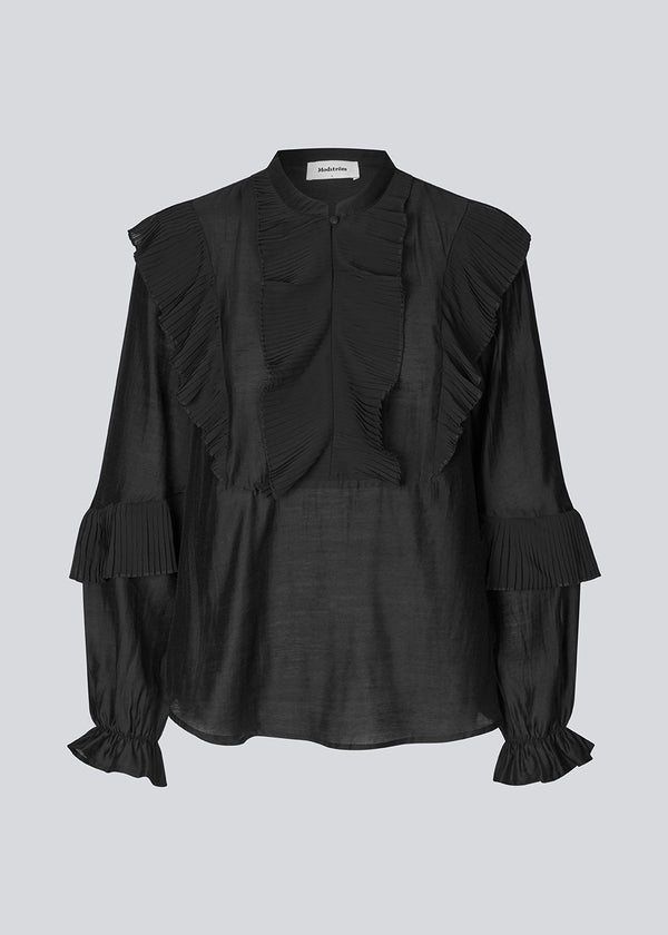 Black Shirt with ruffle details and a front opening. Phungmd shirt has a loose fit and flowy sleeves.