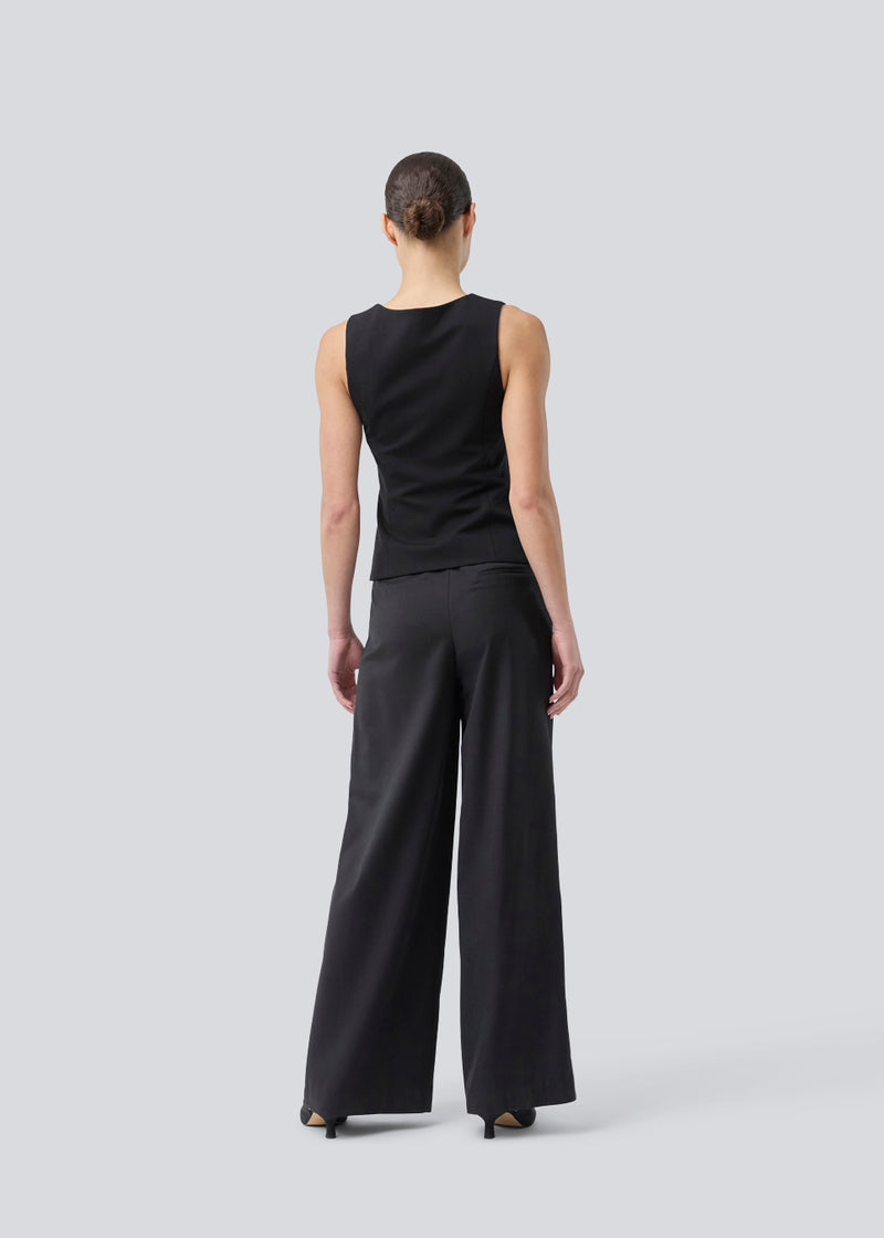 Pants with wide legs, pleats and an elastic waist. Piloumd pants has side pockets and a zipper with button closure in the side. The model is 175 cm and wears a size s/36.