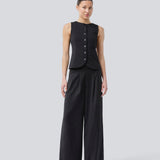 Pants with wide legs, pleats and an elastic waist. Piloumd pants has side pockets and a zipper with button closure in the side. The model is 175 cm and wears a size s/36.