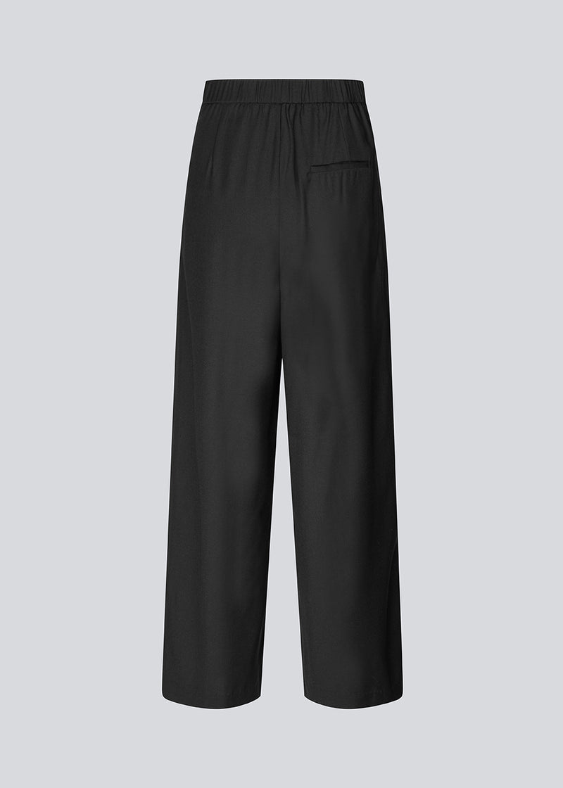Pants with wide legs, pleats and an elastic waist. Piloumd pants has side pockets and a zipper with button closure in the side. The model is 175 cm and wears a size s/36.