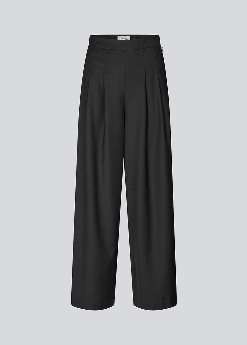 Pants with wide legs, pleats and an elastic waist. Piloumd pants has side pockets and a zipper with button closure in the side. The model is 175 cm and wears a size s/36.