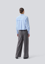 Short shirt in 100% organic cotton. Poemymd shirt has a hidden button closure and cuffs with tie closure. The model is 175 cm and wears a size s/36.