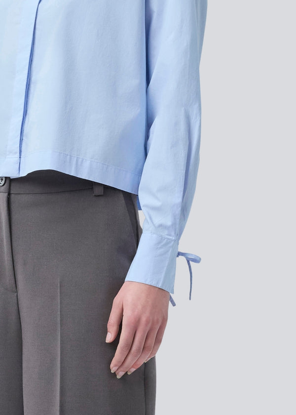 Short shirt in 100% organic cotton. Poemymd shirt has a hidden button closure and cuffs with tie closure. The model is 175 cm and wears a size s/36.