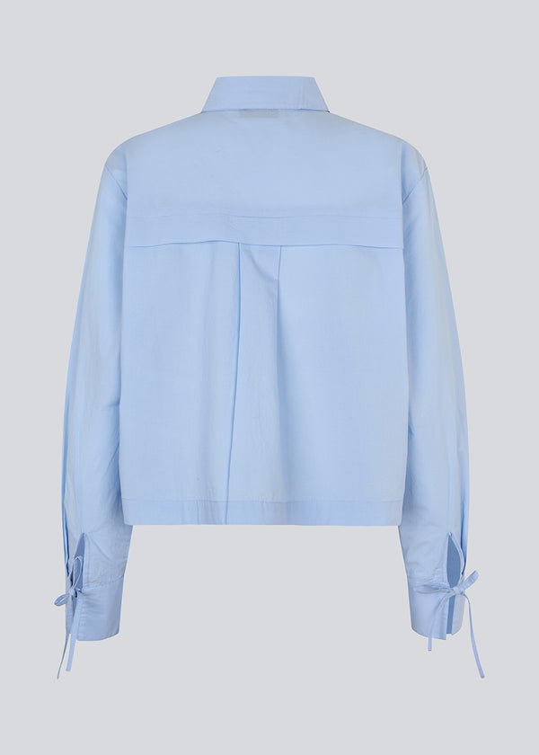 Short shirt in 100% organic cotton. Poemymd shirt has a hidden button closure and cuffs with tie closure. The model is 175 cm and wears a size s/36.