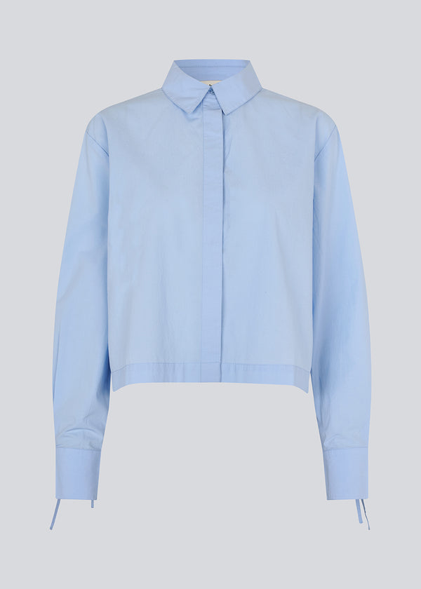 Short shirt in 100% organic cotton. Poemymd shirt has a hidden button closure and cuffs with tie closure. The model is 175 cm and wears a size s/36.