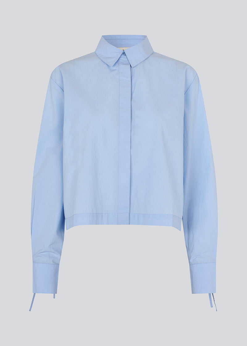 Short shirt in 100% organic cotton. Poemymd shirt has a hidden button closure and cuffs with tie closure. The model is 175 cm and wears a size s/36.