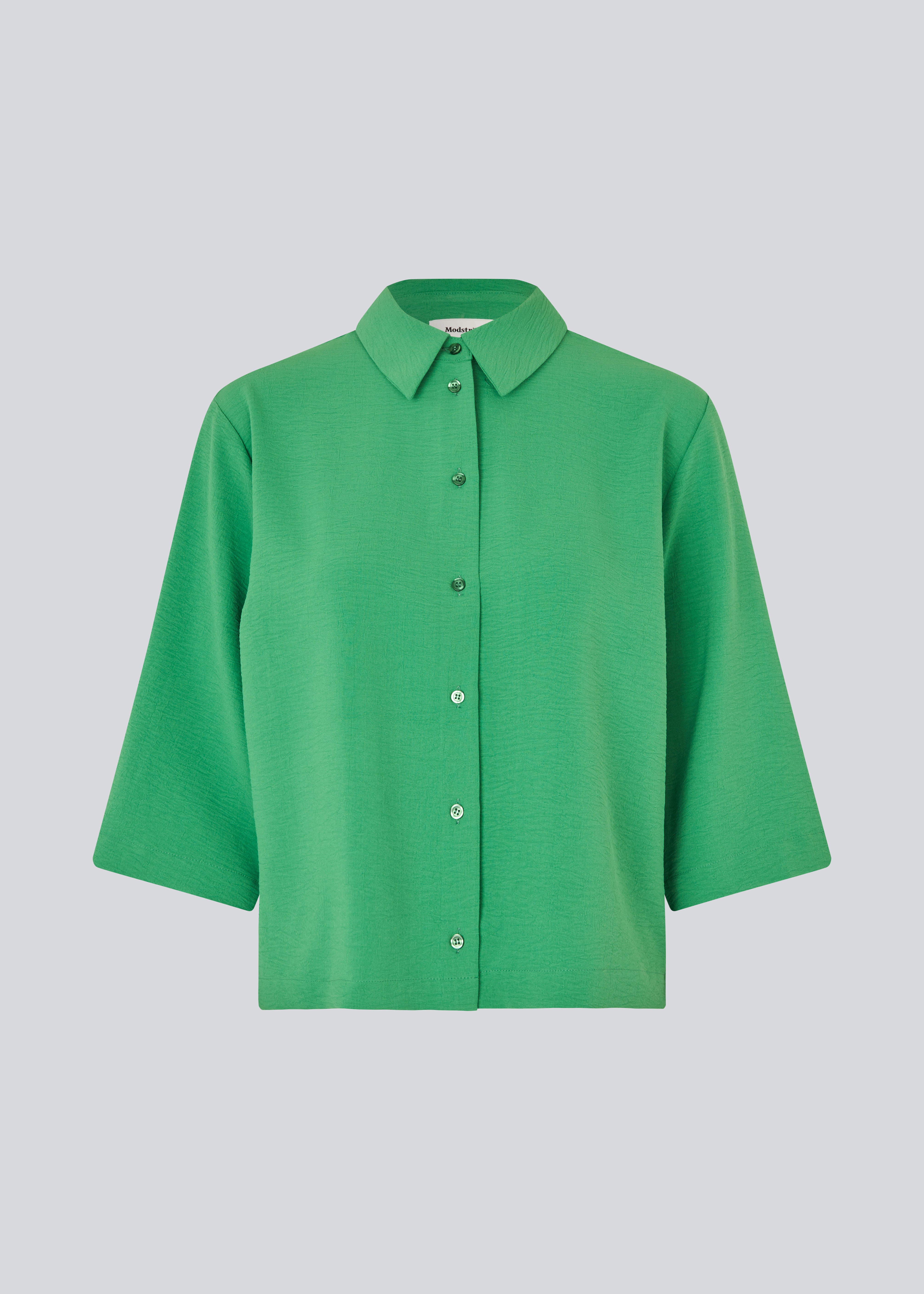 Shirt with 3/4 sleeves in 100% recycled polyester.  Popelmd shirt has a loose fit and button closure in front. The model is 175 cm and wears a size s/36.