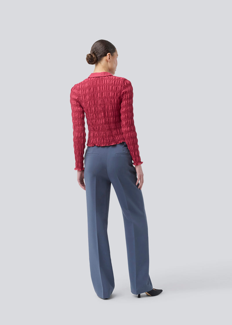 Fitted long-sleeved top in smock. Posiemd shirt has a button closure and a shirt collar. The model is 175 cm and wears a size s/36.