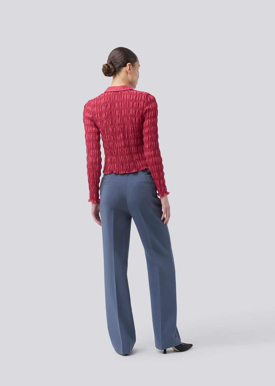Fitted long-sleeved top in smock. Posiemd shirt has a button closure and a shirt collar. The model is 175 cm and wears a size s/36.