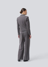 Grey short fitted blazer. Primrosemd blazer has a button closure and two front pockets. The model is 175 cm and wears a size s/36.