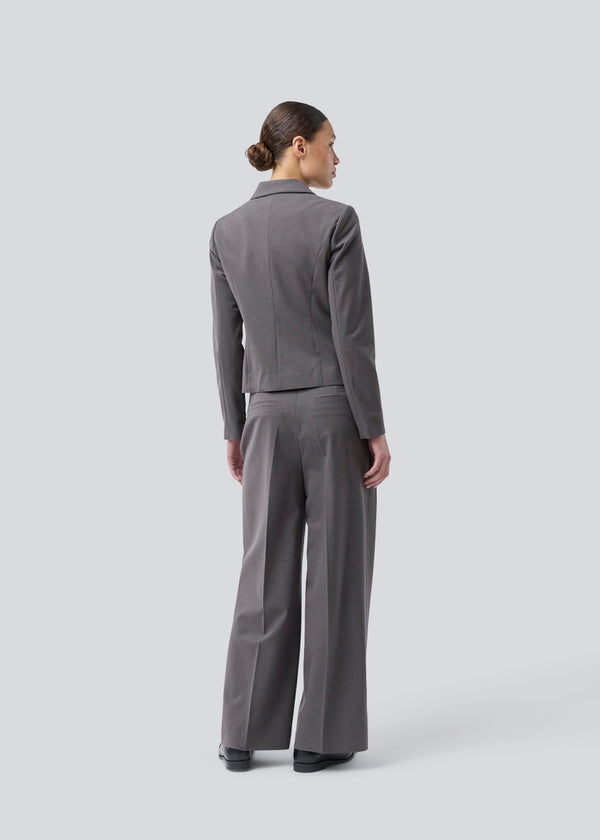 Grey short fitted blazer. Primrosemd blazer has a button closure and two front pockets. The model is 175 cm and wears a size s/36.
