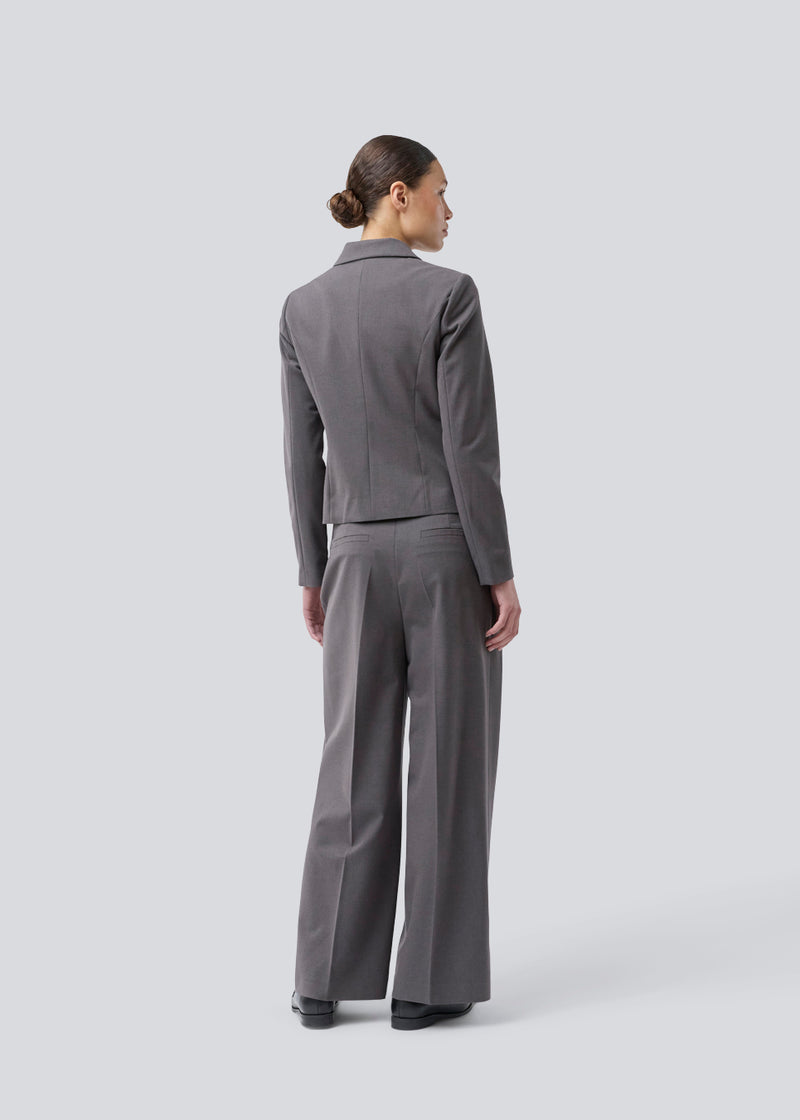 Grey short fitted blazer. Primrosemd blazer has a button closure and two front pockets. The model is 175 cm and wears a size s/36.