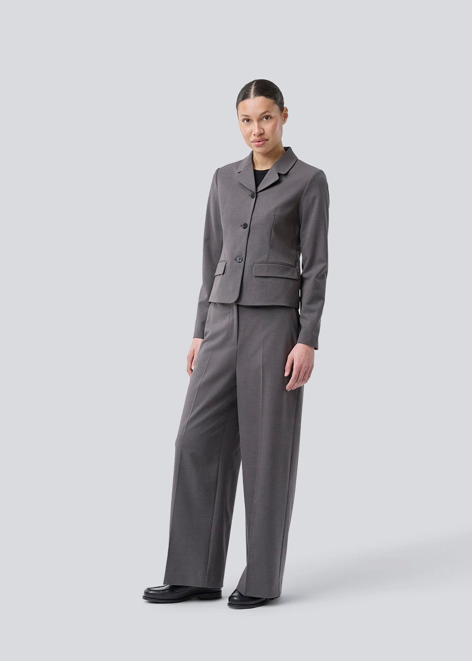 Grey short fitted blazer. Primrosemd blazer has a button closure and two front pockets. The model is 175 cm and wears a size s/36.