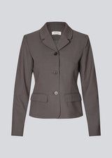 Grey short fitted blazer. Primrosemd blazer has a button closure and two front pockets. The model is 175 cm and wears a size s/36.