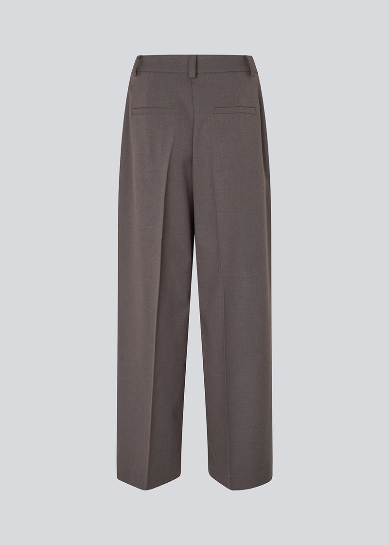 Grey long suit trousers with wide legs. Primrosemd pants have pleats and side pockets. The model is 175 cm and wears a size s/36.