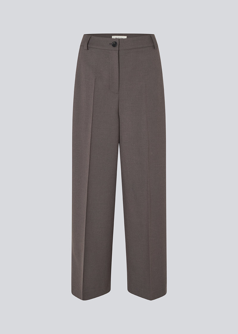 Grey long suit trousers with wide legs. Primrosemd pants have pleats and side pockets. The model is 175 cm and wears a size s/36.
