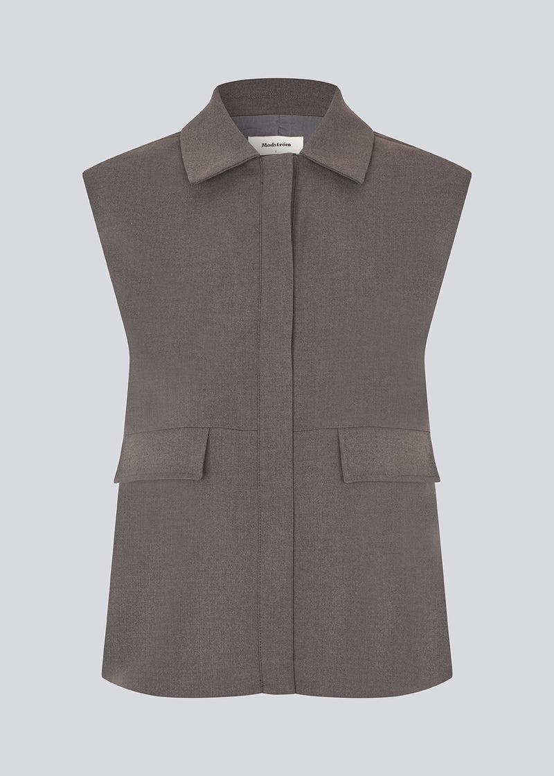 Grey loose vest with a hidden front button closure. Primrosemd vest has a shirt collar and two front pockets.&nbsp;
