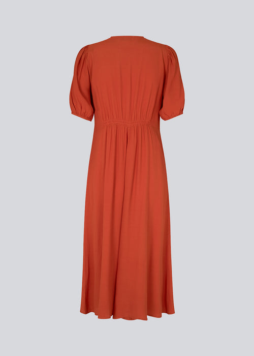 Feminine dress in red solid EcoVero viscose. RavenMD long dress is full length with flattering smock details on shoulder and waist. The model is 173 cm and wears a size S/36