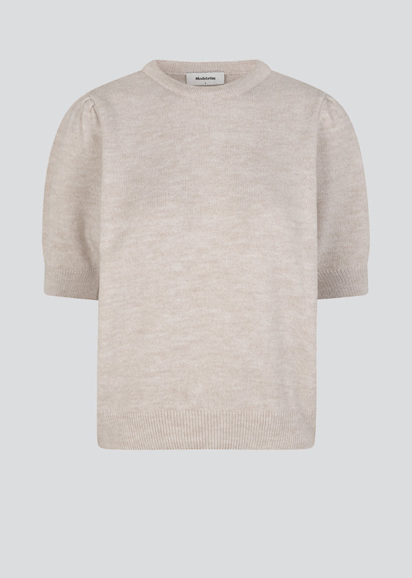 Soft knit in beige with short puffed sleeves. Rhonda o-neck is designed with a round neck and ribbed trimmings on sleeves, bottom and neck. The model is 173 cm and wears a size S/36